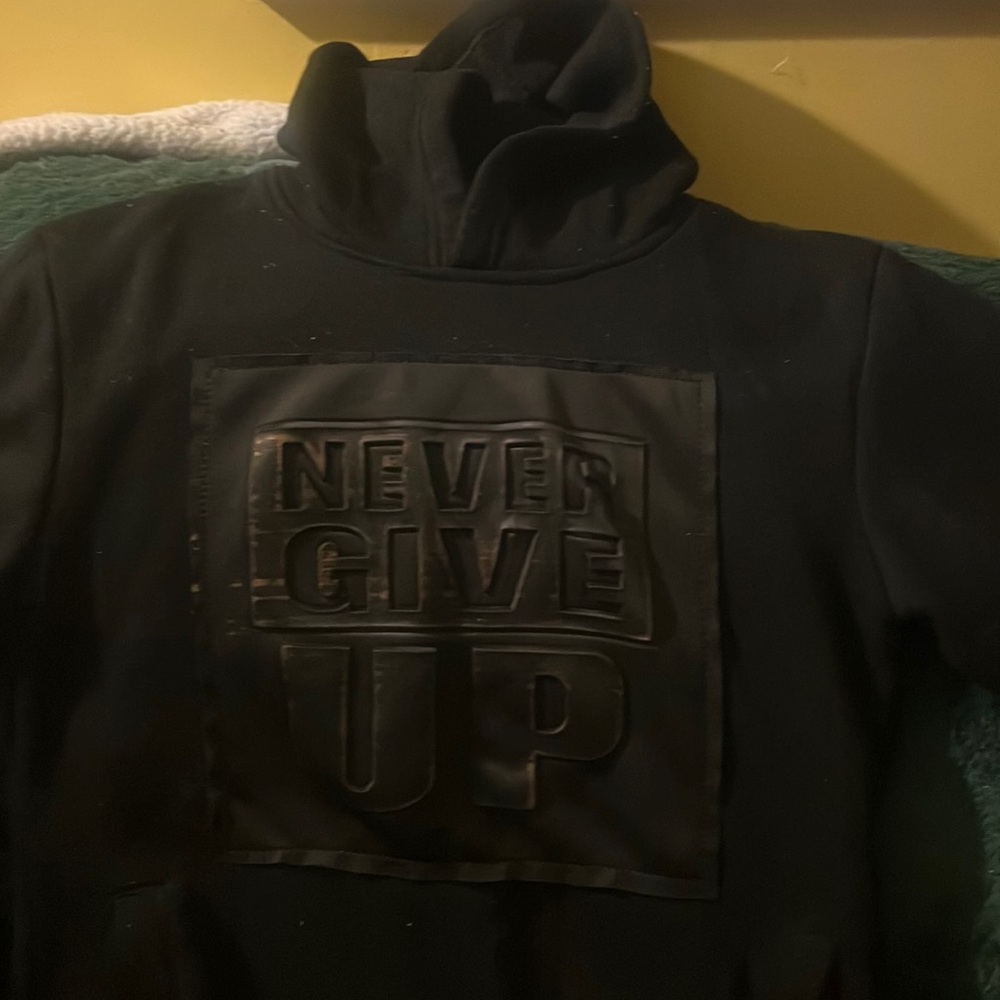 Black Hoodie that says Never Give Up on the front Never Surrender left sleeve